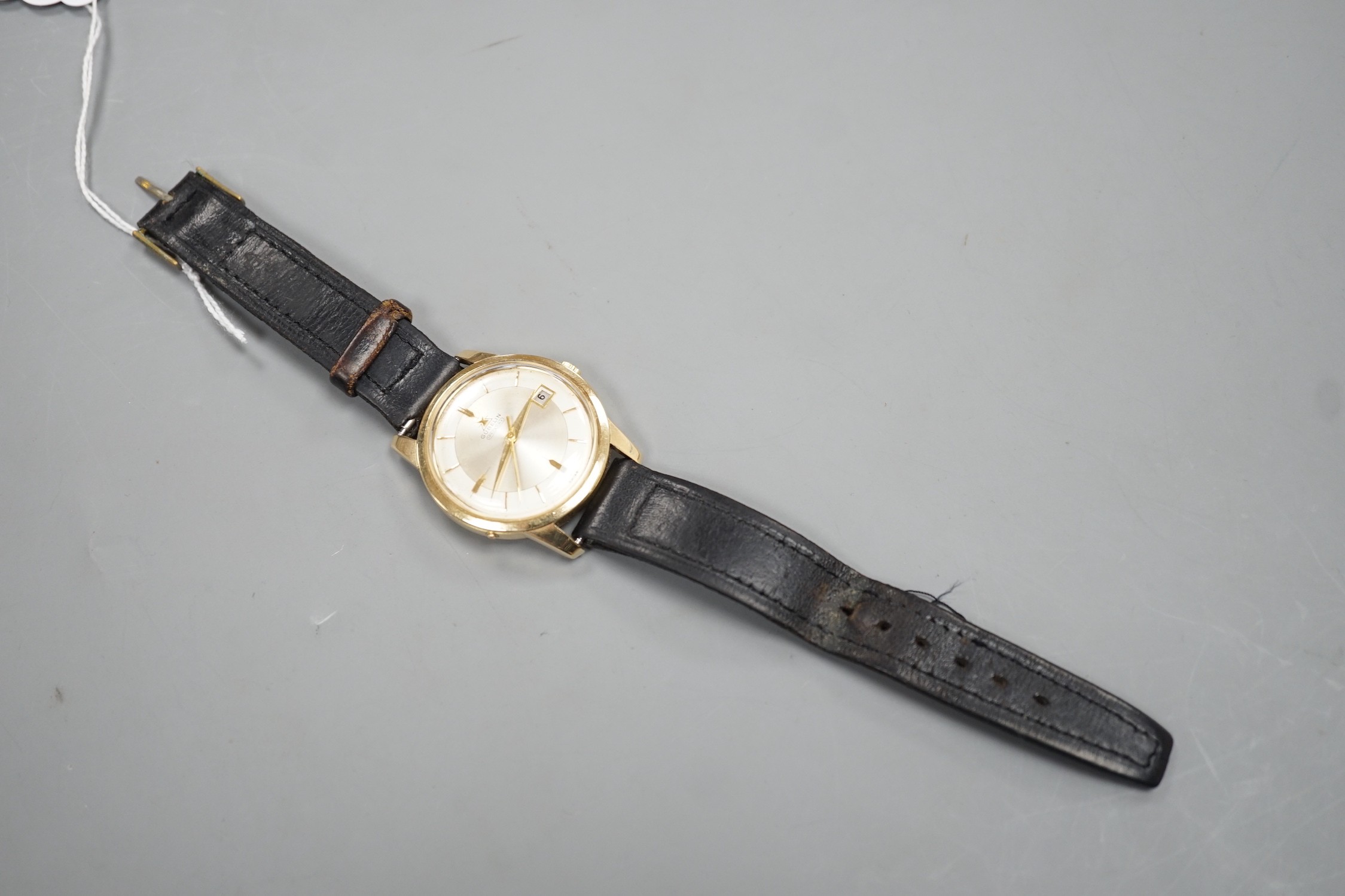 A gentleman's 14ct gold Gubelin Ipso Day automatic wrist watch, with baton numerals and date aperture, on associated leather strap, the case back with engraved initials, case diameter 35mm